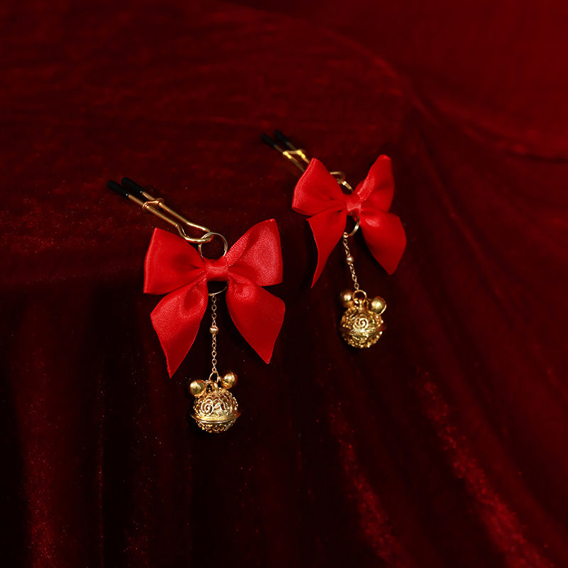 Close-up of red nipple clamp with metal tip and bell charm – Velalace